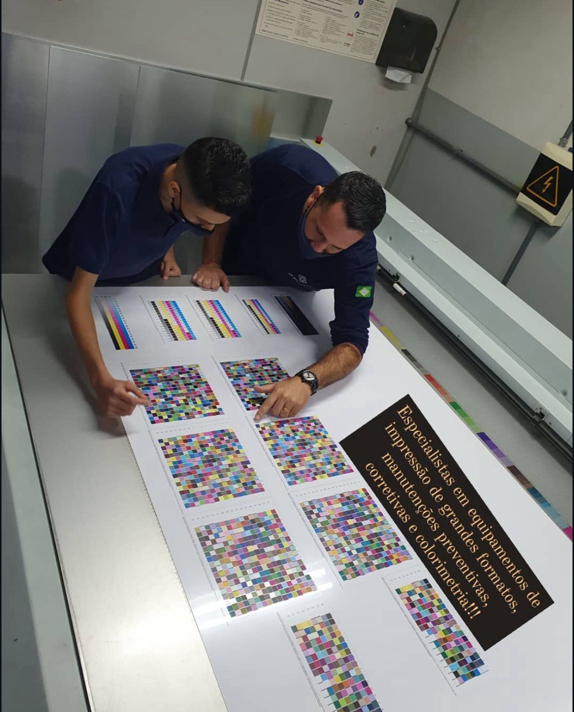 Técnicos da DG realizando análise de colorimetria em impressão de grande formato